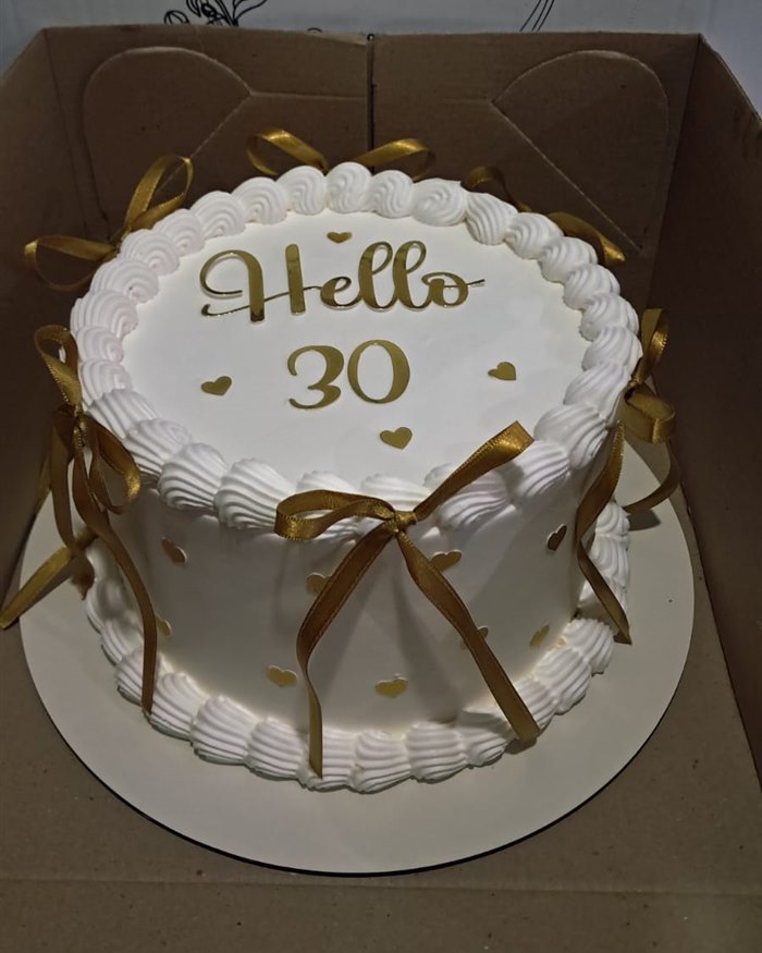 Bolo branco com laços dourados para aniversário de 30 anos