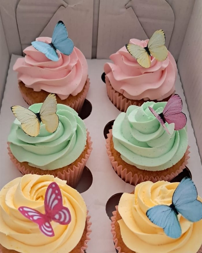Seis cupcakes coloridos com borboletas comestíveis